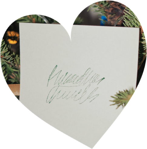 A heart-shaped capture of a handwritten card among plants.